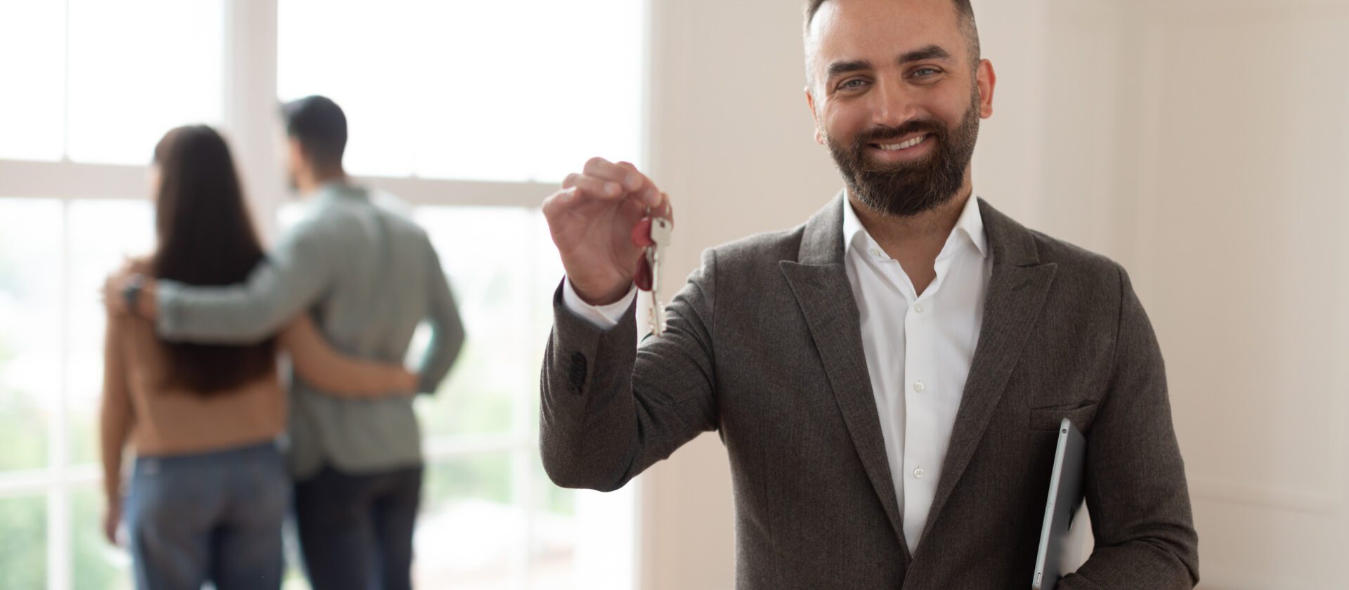 Portrait Of Smiling Real Estate Agent Holding And Showing Key