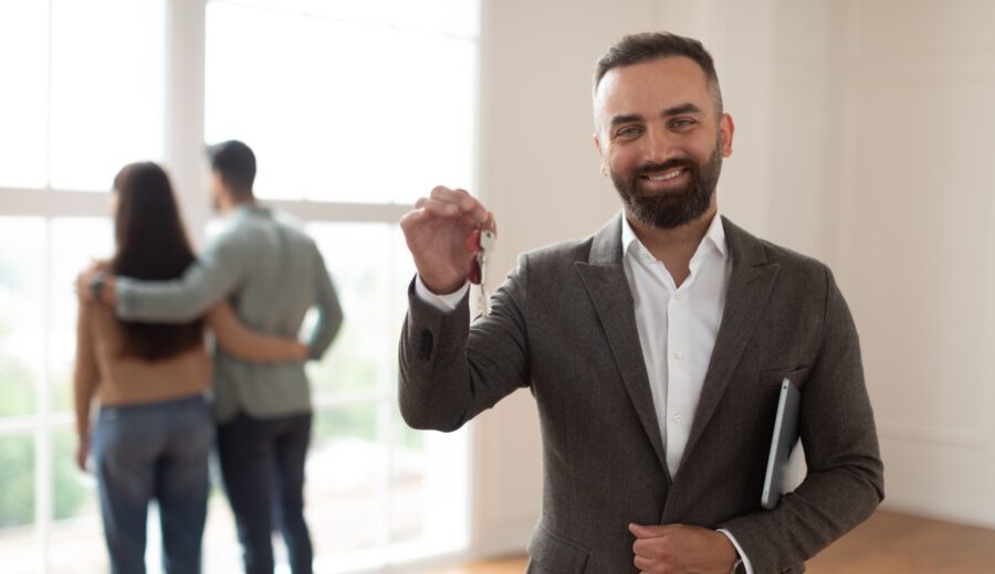 Portrait Of Smiling Real Estate Agent Holding And Showing Key