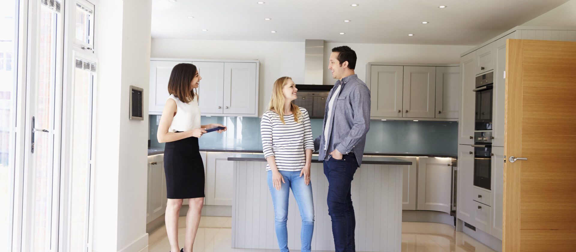 Realtor Showing Young Couple Around Property For Sale