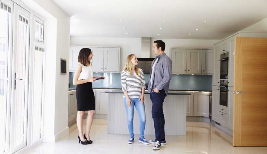 Realtor Showing Young Couple Around Property For Sale