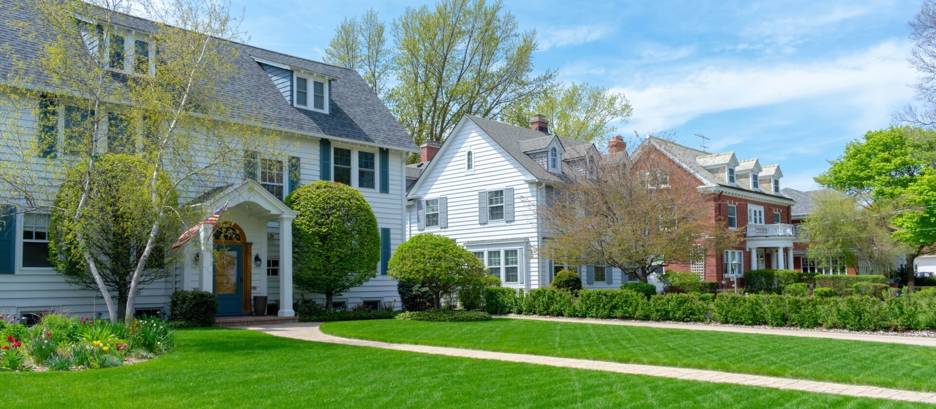 Traditional suburban homes with green front lawns